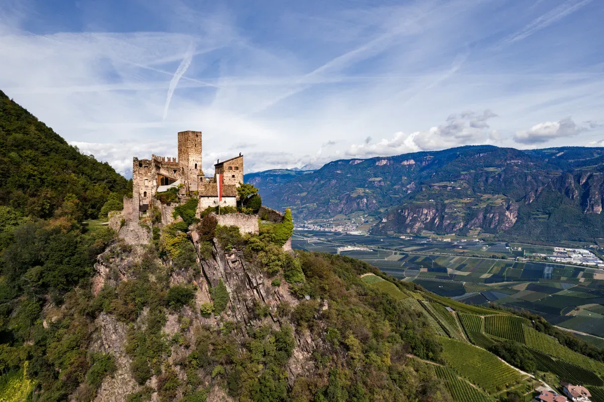 Un castello su uno sperone roccioso sopra una valle alpina