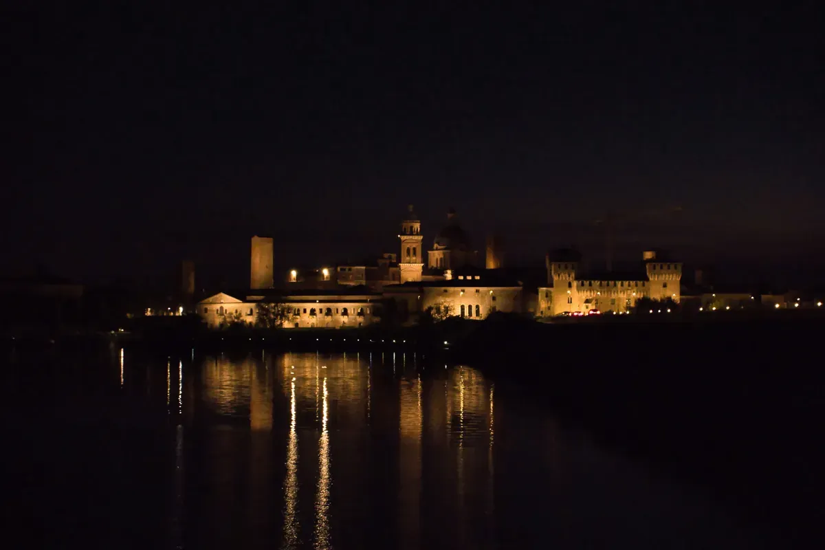 Mantova illuminata di notte, riflessa nel lago