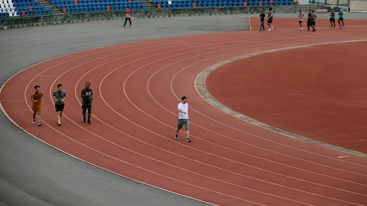 Persone che corrono sulla pista di uno stadio