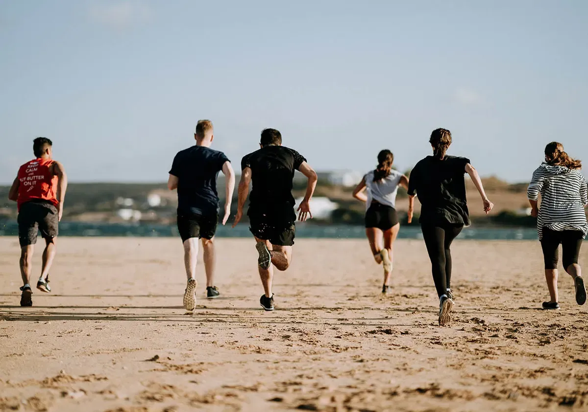 Gruppo di ragazzi che corre in spiaggia