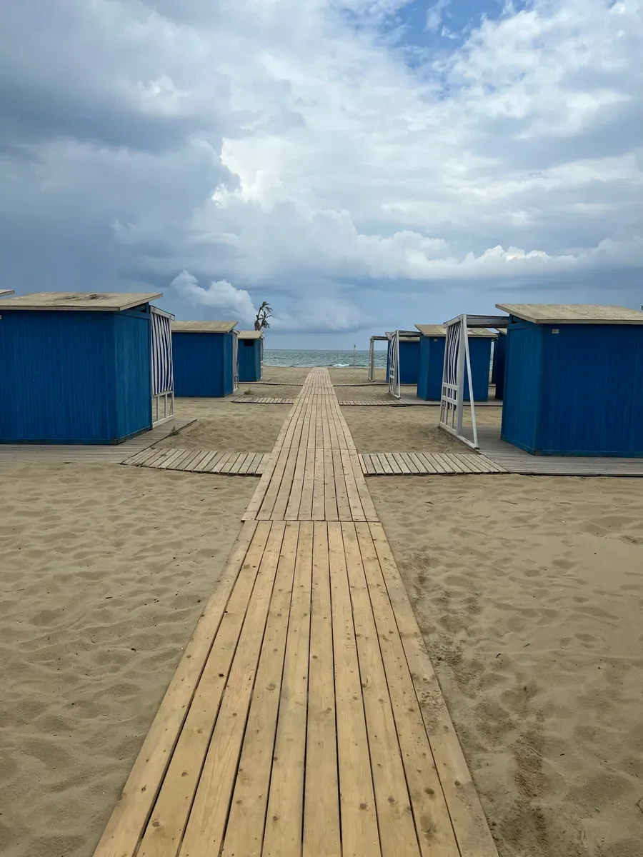 Una passerella in legno tra le cabine di uno stabilimento sulla spiaggia