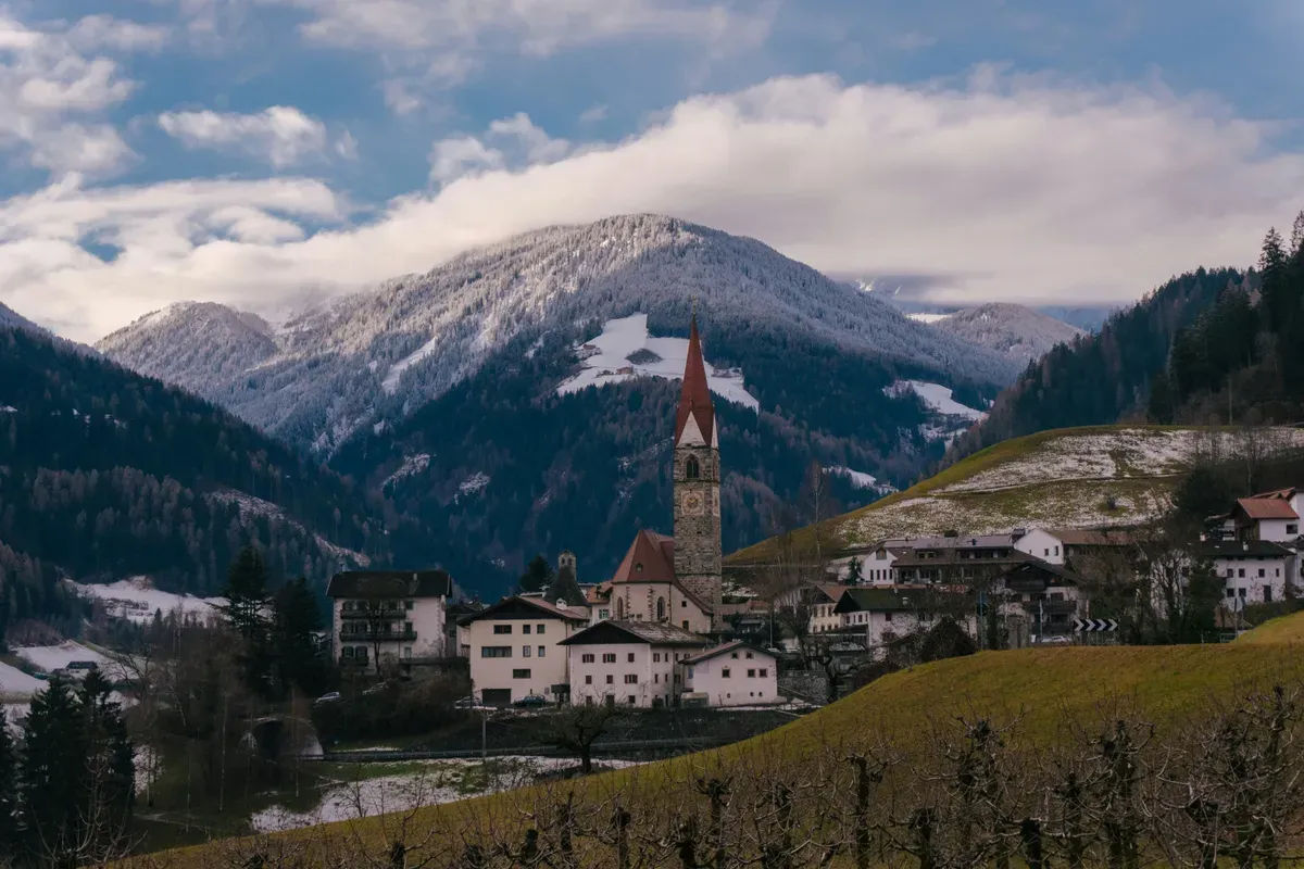 Un paese con il campanile tra le montagne del Trentino