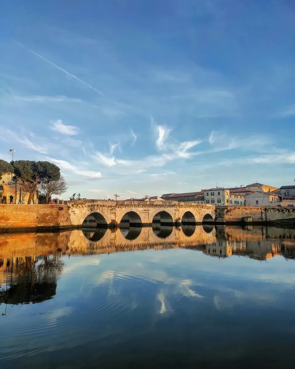 Il Ponte di Tiberio riflesso nell'acqua al tramonto