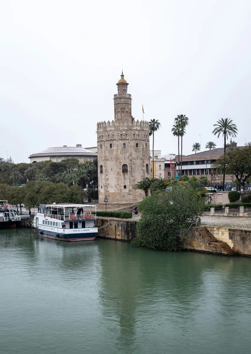 La Torre del Oro sulla riva del Guadalquivir, con le palme