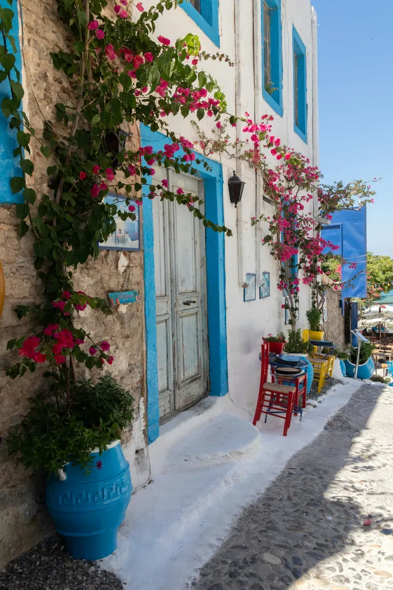 Una casa con le porte blu e i fiori in un villaggio di Kos