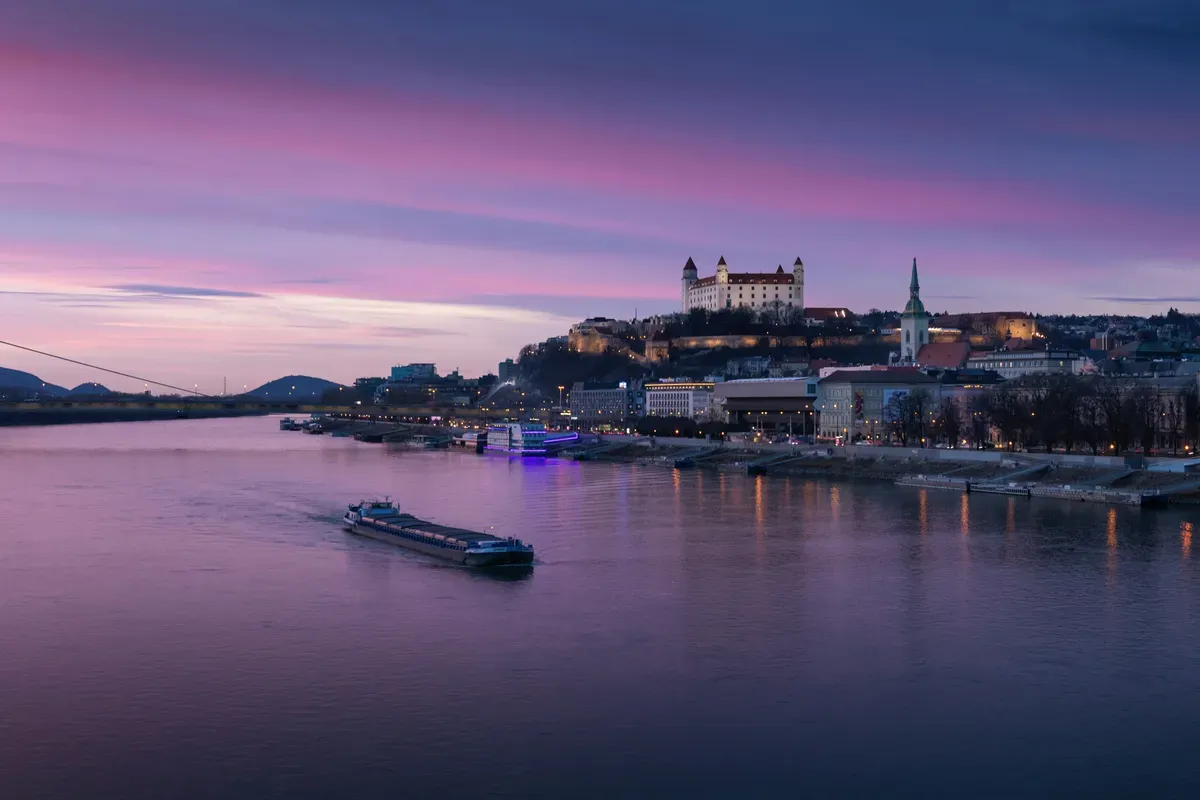 Il Danubio al tramonto con il castello di Bratislava sulla collina