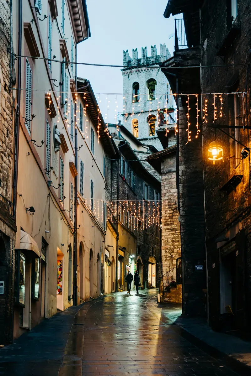 Una via del centro con le luci accese al tramonto