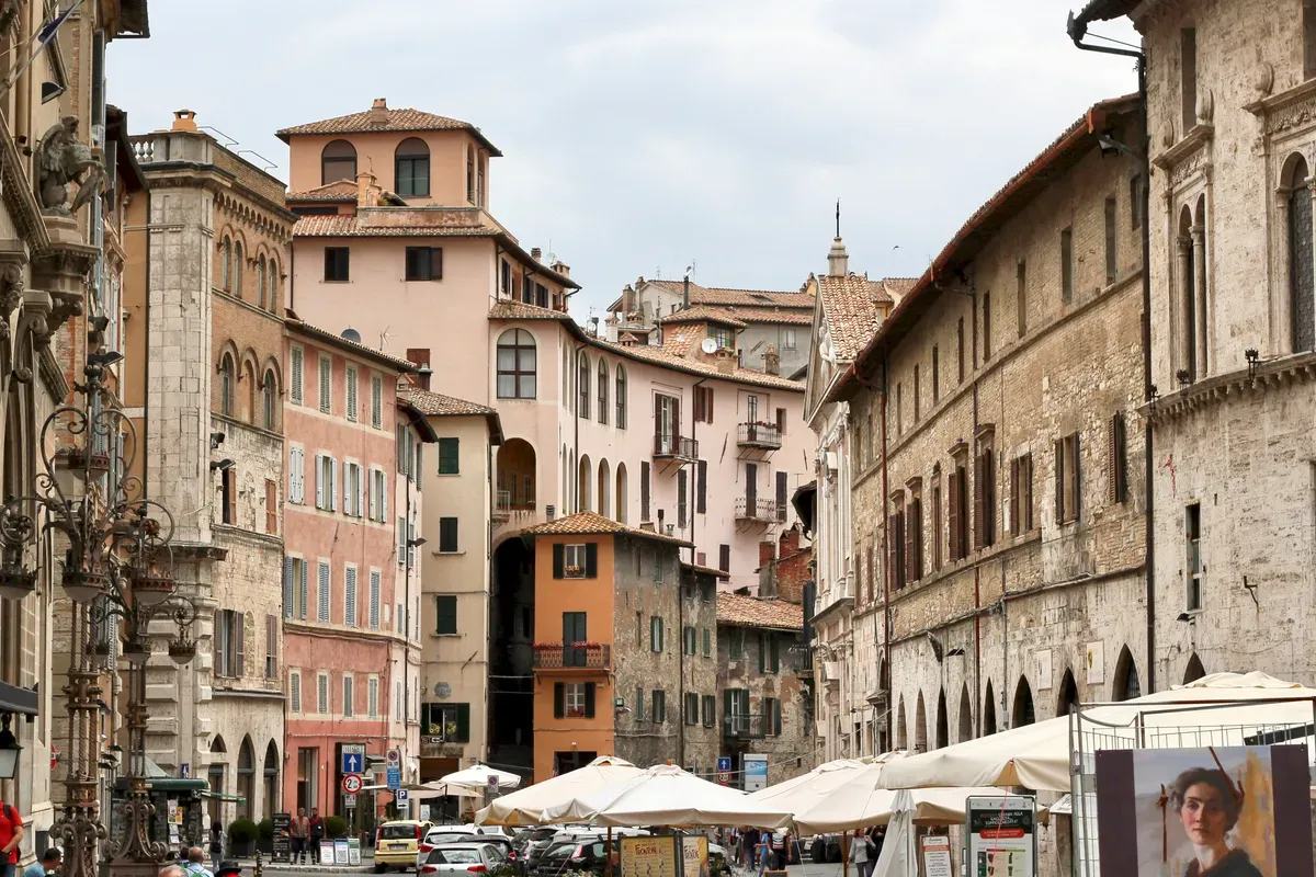 Una via del centro di Perugia con i palazzi storici e i tavolini dei bar