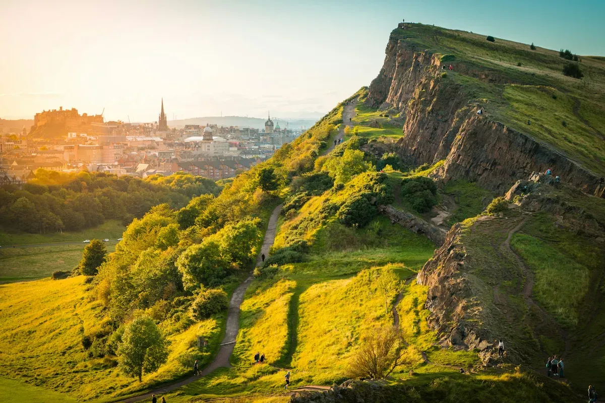 Salisbury Crags e il sentiero su Arthur's Seat al tramonto, con Edimburgo sullo sfondo