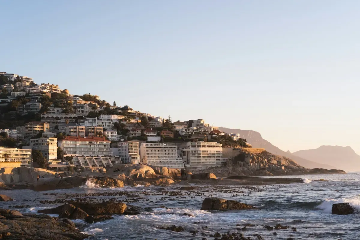 La costa di Città del Capo al tramonto, con i palazzi sul mare e le montagne sullo sfondo
