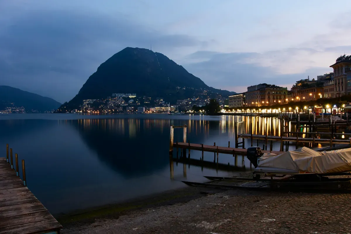 Il lungolago di Lugano al crepuscolo con il Monte San Salvatore