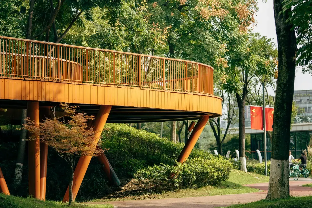 Una passerella in legno tra gli alberi di un parco di Chengdu