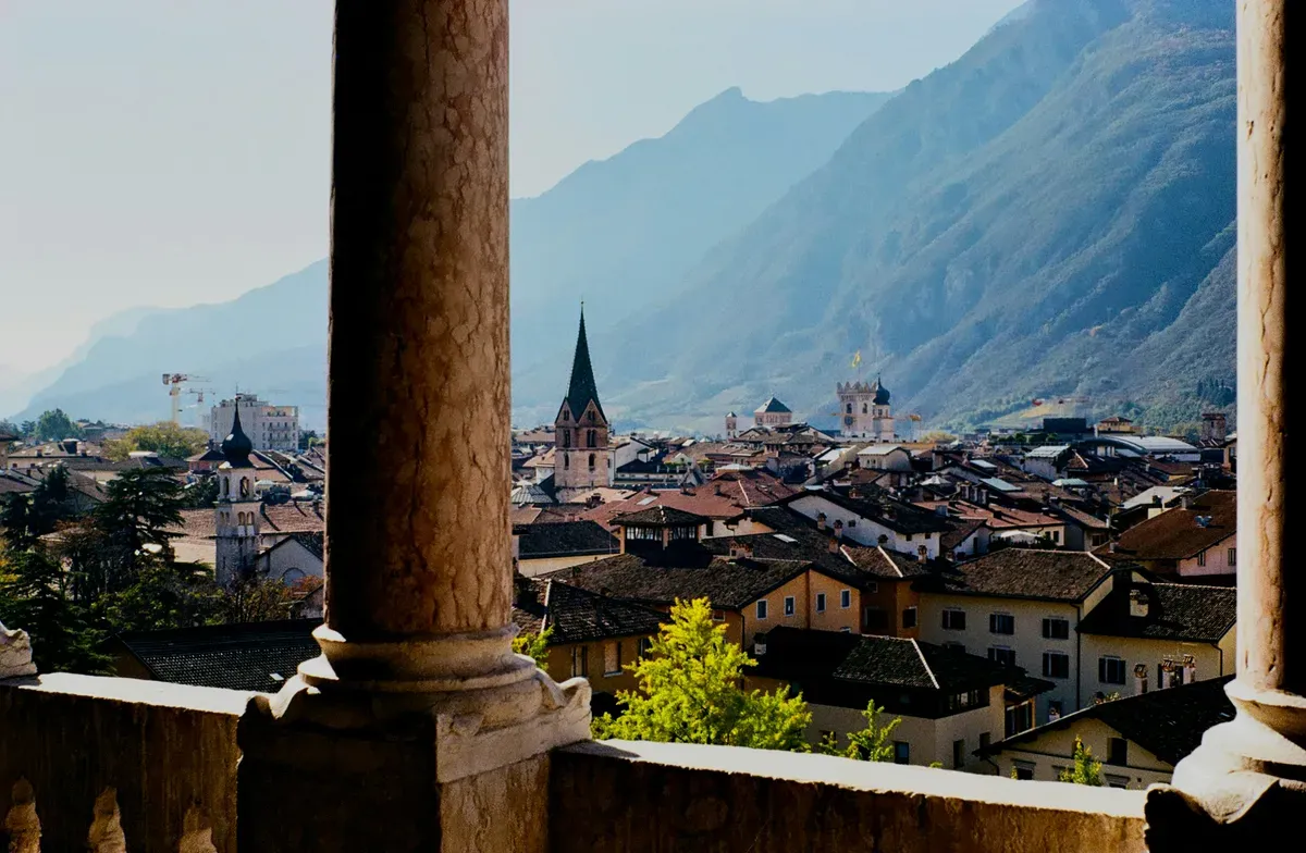 I tetti di Trento visti da una loggia, con le montagne sullo sfondo