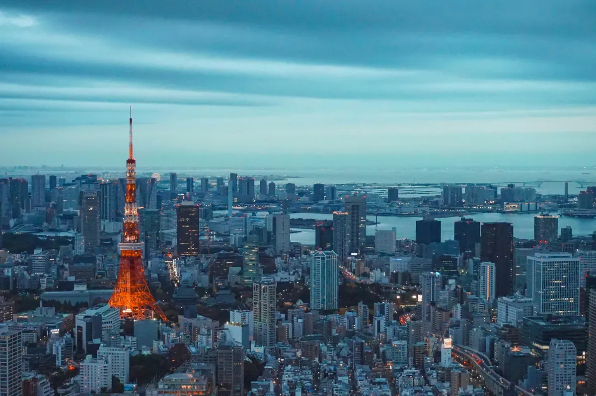 La Tokyo Tower illuminata tra i grattacieli di Tokyo, con la baia sullo sfondo