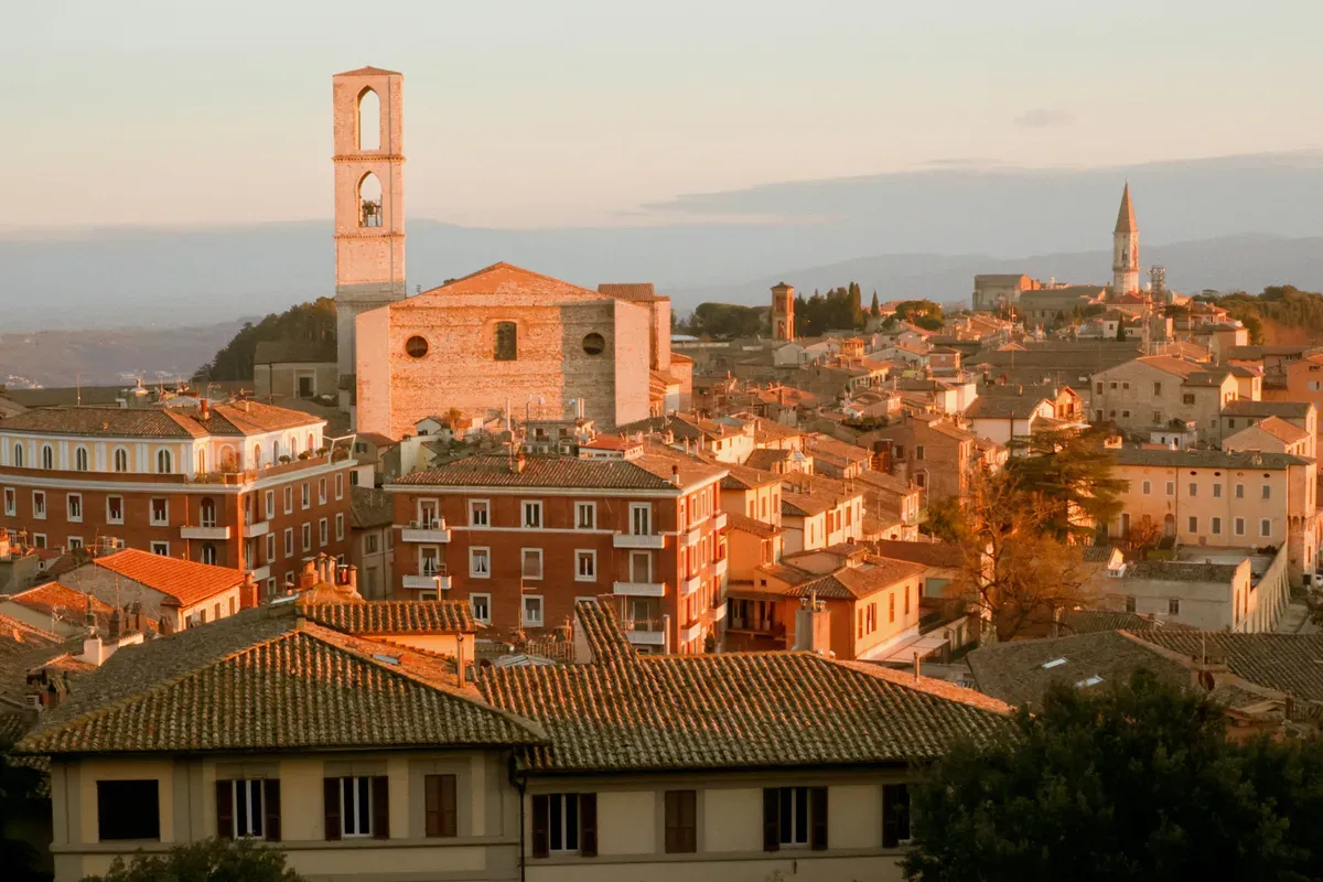 Perugia al tramonto, con i campanili e le case in mattoni
