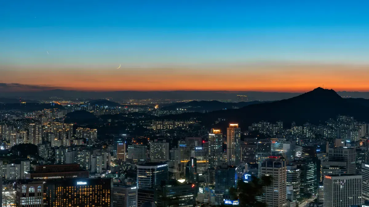 Seul al tramonto vista dall'alto, con i grattacieli del centro e le montagne sullo sfondo