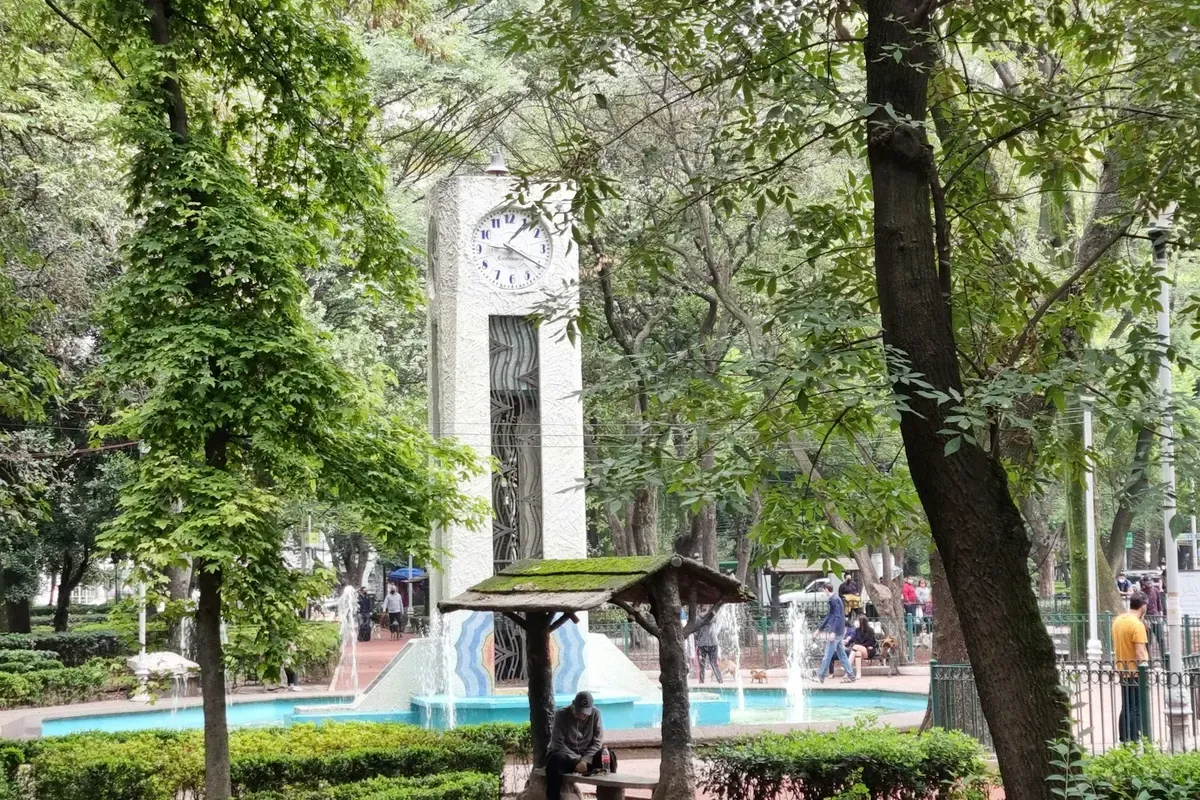 La fontana e la torre dell'orologio in un parco alberato di Città del Messico