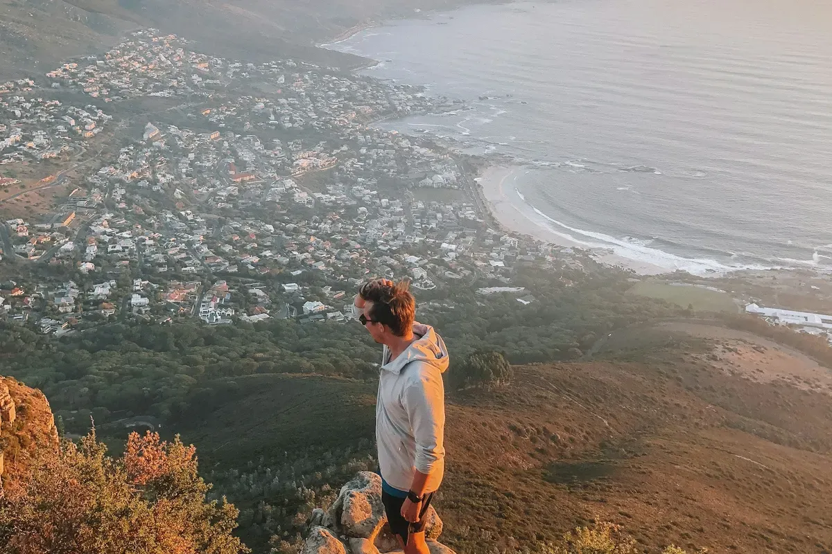 Un ragazzo su una roccia sopra la costa di Città del Capo