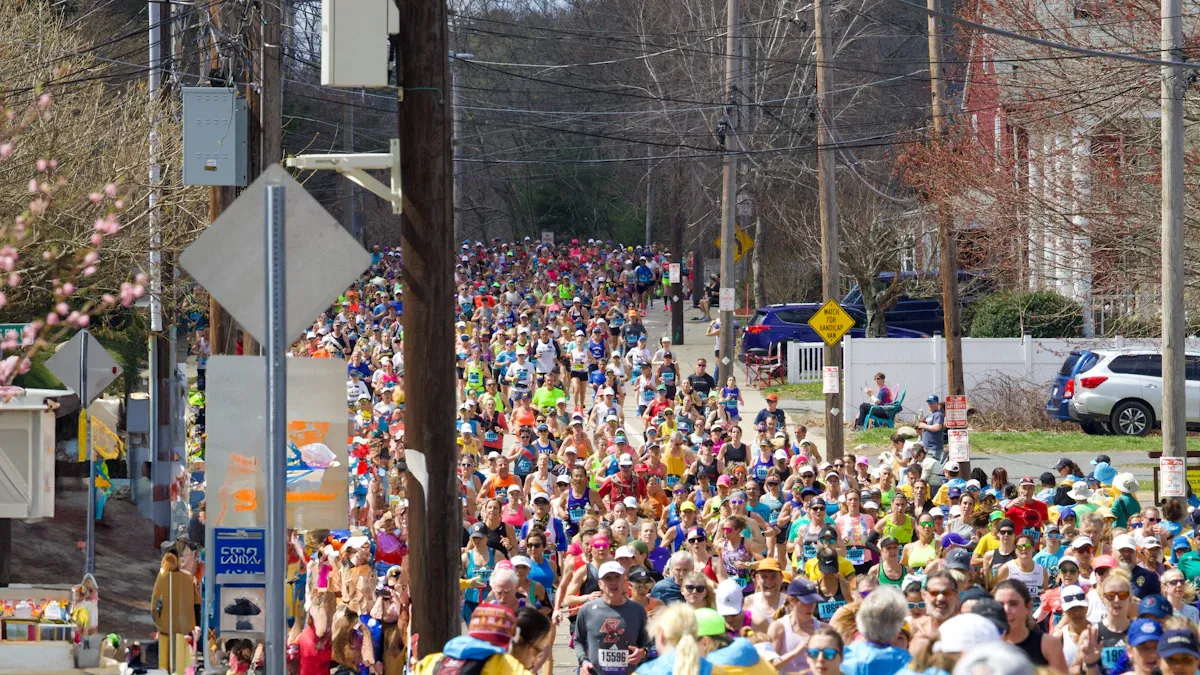 Migliaia di runner riempiono una strada tra le case durante la maratona di Boston