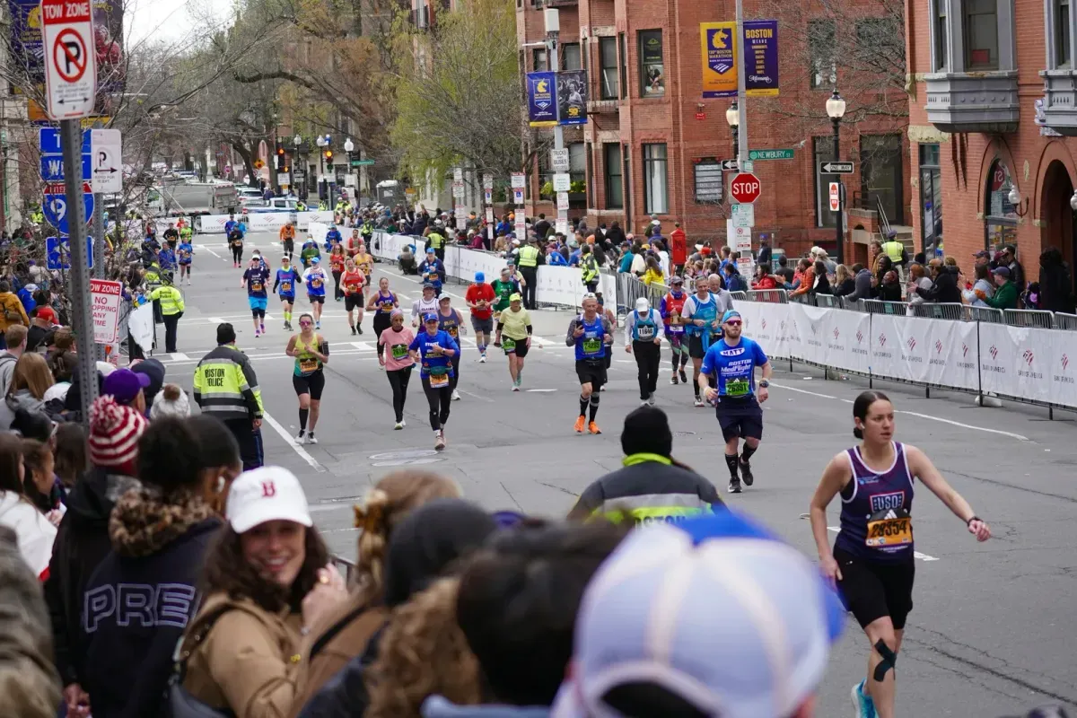 Runner della maratona di Boston tra gli spettatori, con i banner della B.A.A.