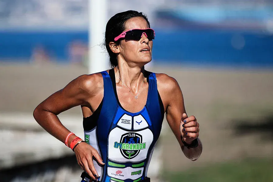 Correre con il caldo una ragazza che corre sotto il sole durante una gara di triathlon