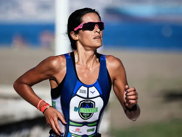 Correre con il caldo una ragazza che corre sotto il sole durante una gara di triathlon