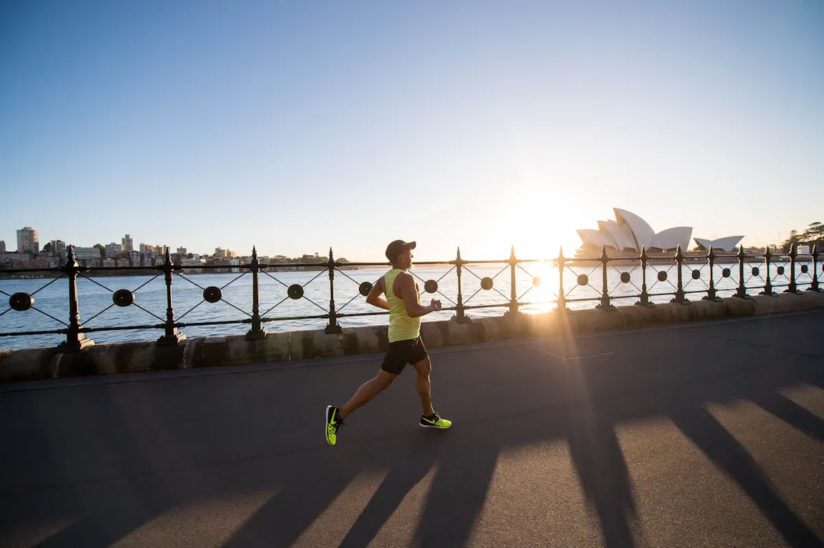 Un runner sul lungomare di Sydney all'alba, con la Sydney Opera House sullo sfondo